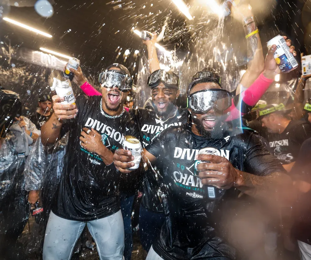 Julio Rodriguez, Victor Robles, and Randy Arozarena celebrate Seattle’s AL West title Wednesday at T-Mobile Park, in Seattle